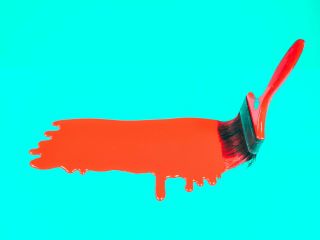 Kwast met druipende rode verf op turquoise achtergrond